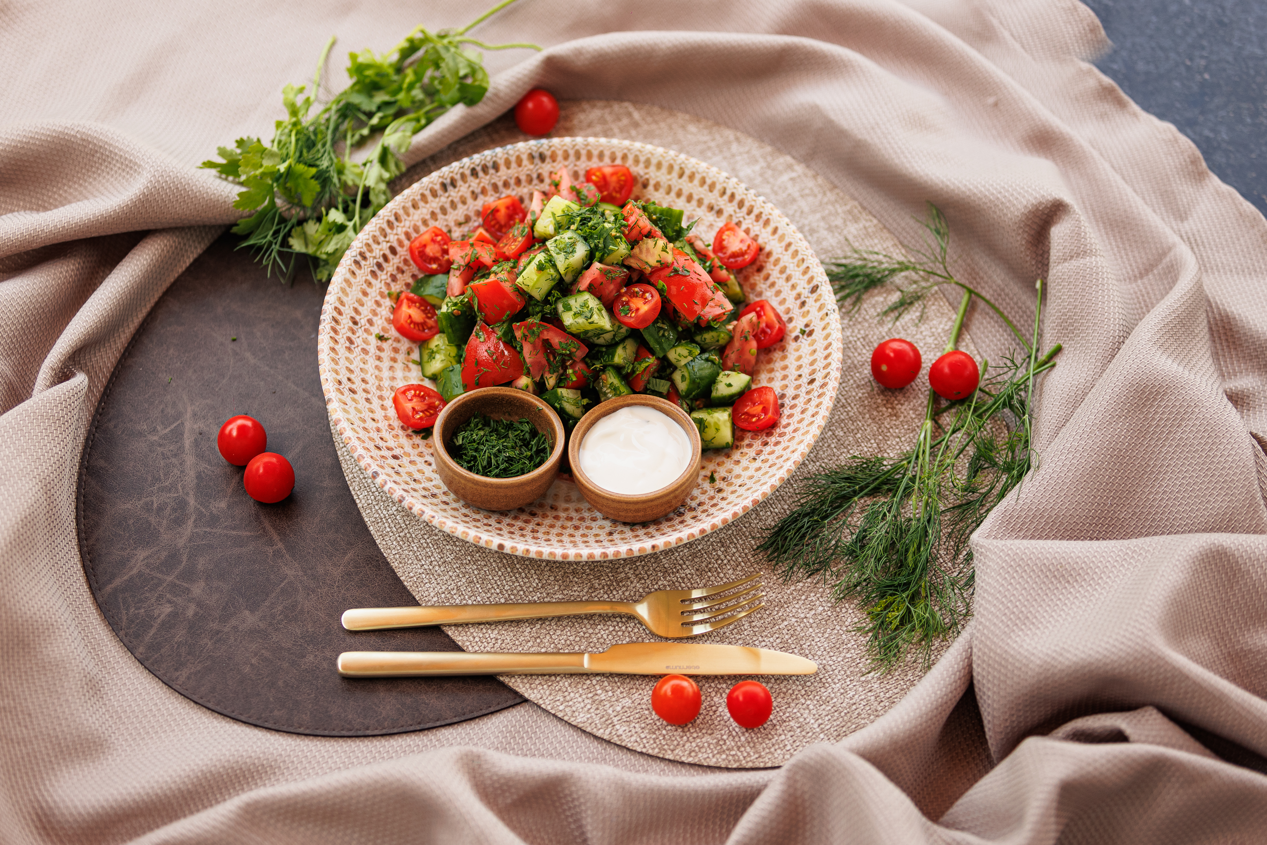 Appetizers on a round woven plate with dipping sauces